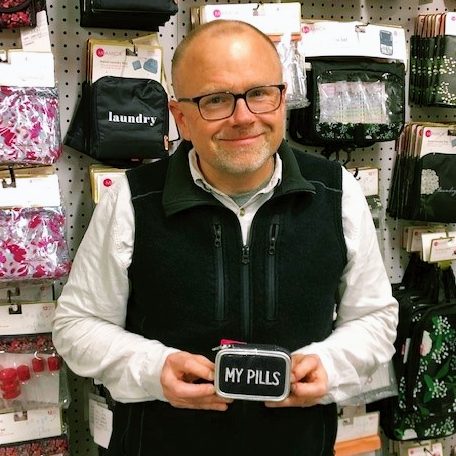 Image of employee showing off his pill case.