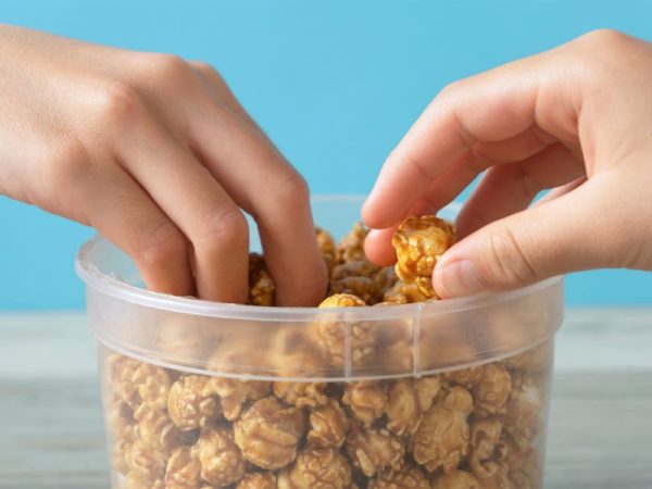 Two people share a container of snacks