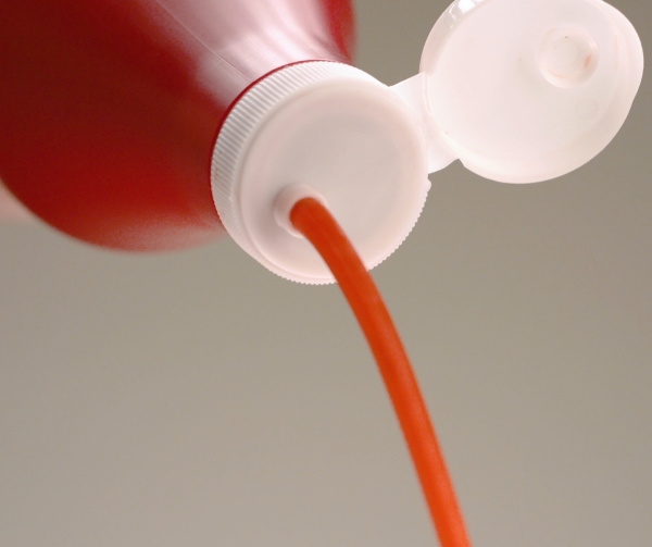 Dispensing Cap Dispensing red sauce out the top