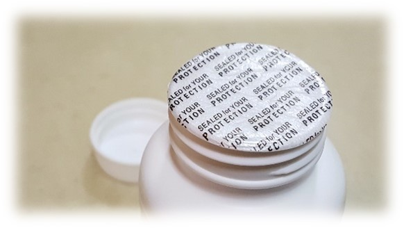 Image of a Pressure Sensitive (PS) Liner on a cap. Text on the liner says "Sealed for your Protection." 